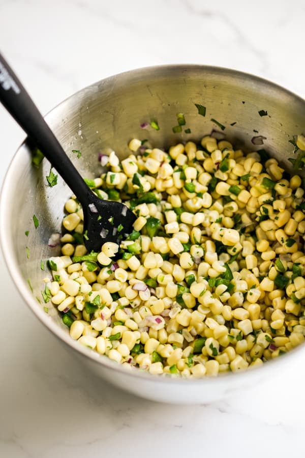 Corn kernels, jalapeño, red onions, cilantro, lime and lemon juice mixed together in a large mixing bowl