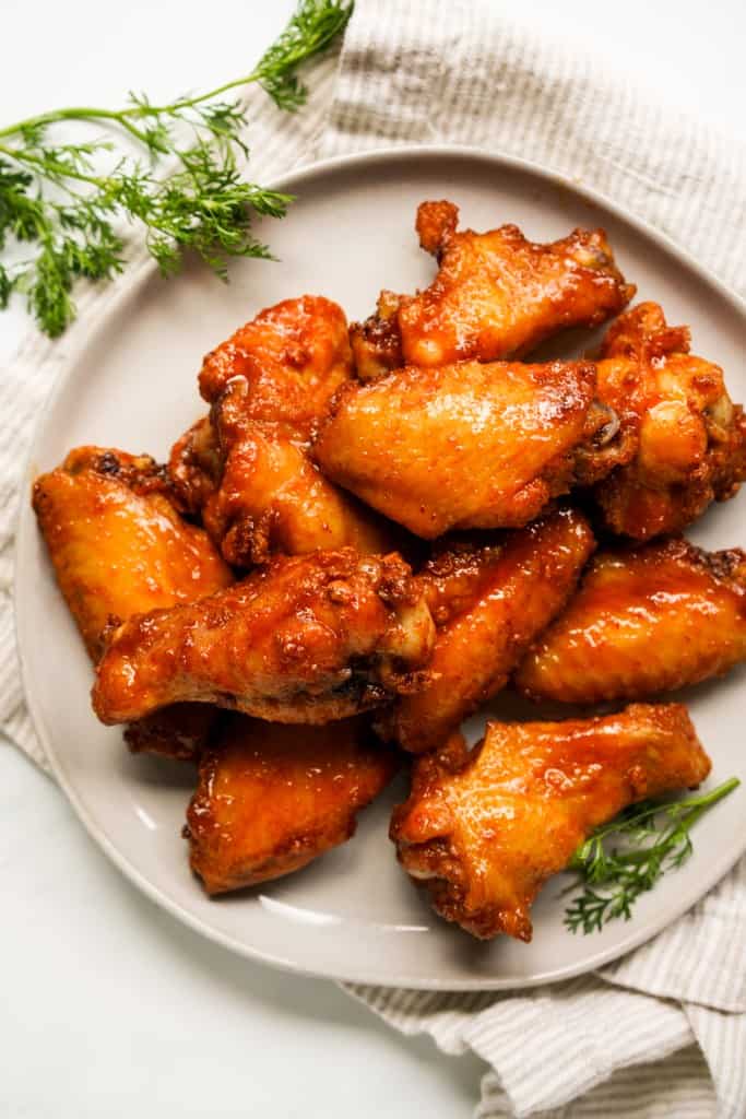 A plate loaded with sticky hot honey wings