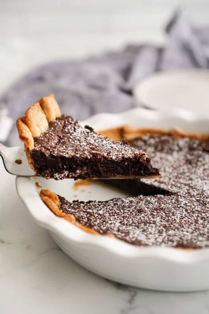 Lifting up a slice of chocolate chess pie 