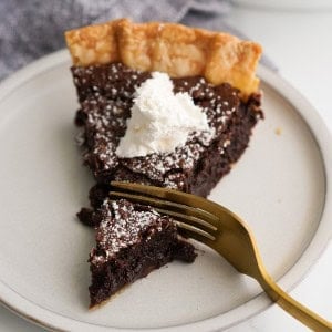 Digging into a piece of chocolate chess pie with a fork
