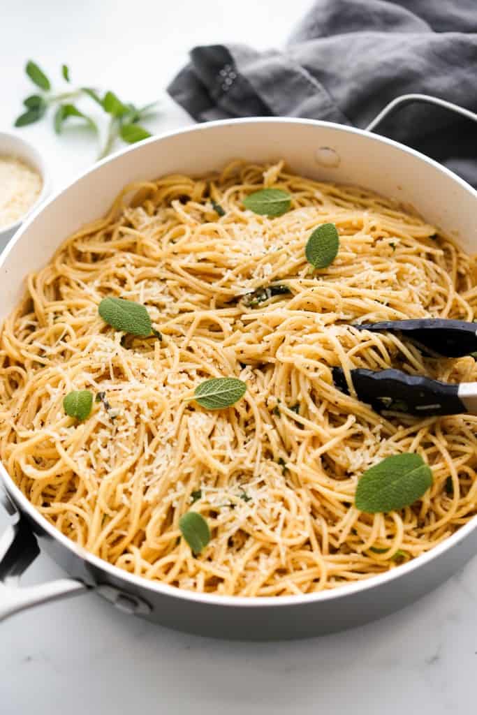 A large pot of spaghetti tossed in brown butter,  sage and garlic.