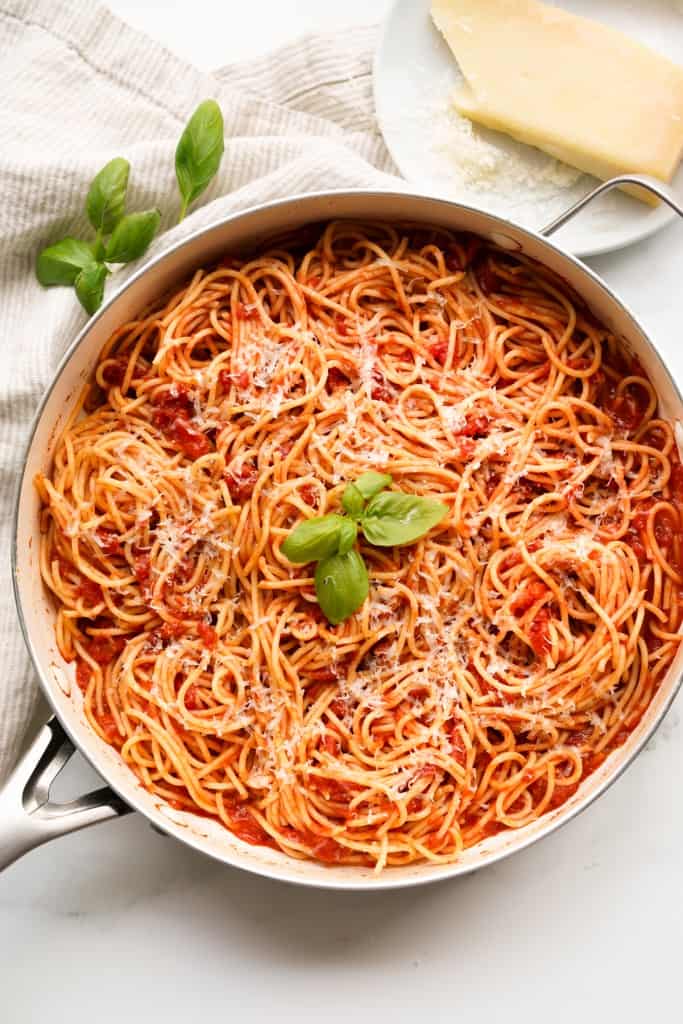 A large pot of spaghetti tossed in a pomodoro tomato basil sauce