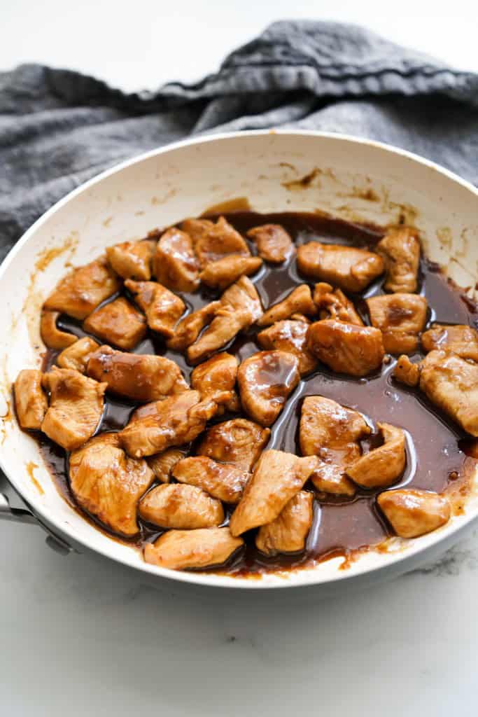 chicken cubes in skillet coated in thick soy glaze