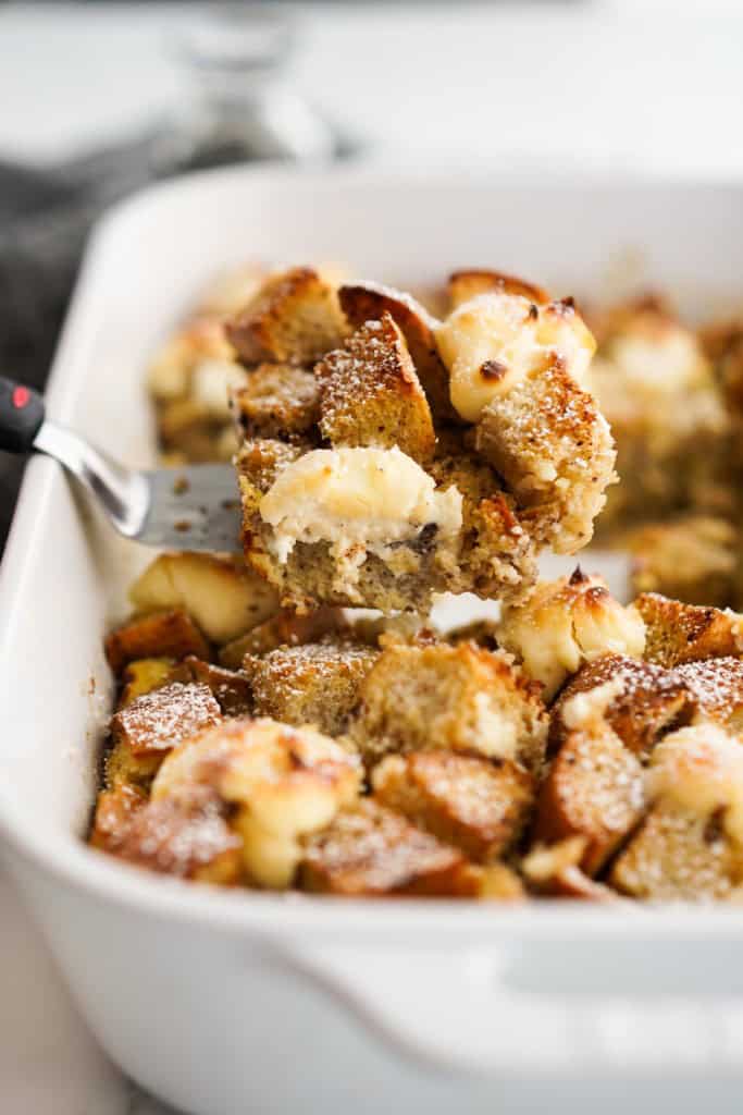 Lifting up a slice of french toast casserole from baking dish