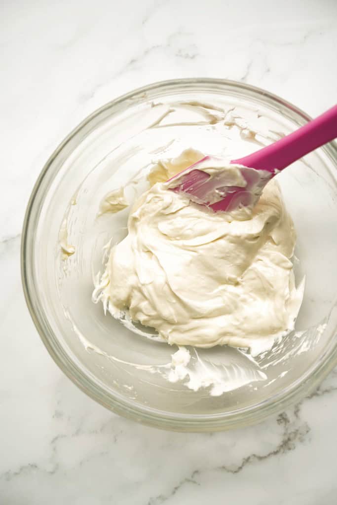 Sweetened cream cheese filling in a clear mixing bowl