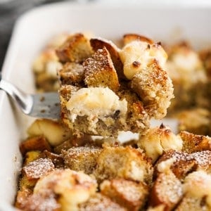 Lifting up a piece of cream cheese French toast bake from the pan