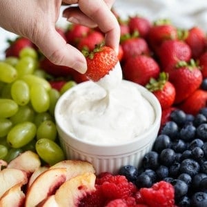 Dipping strawberries into a bowl of marshmallow fruit dip