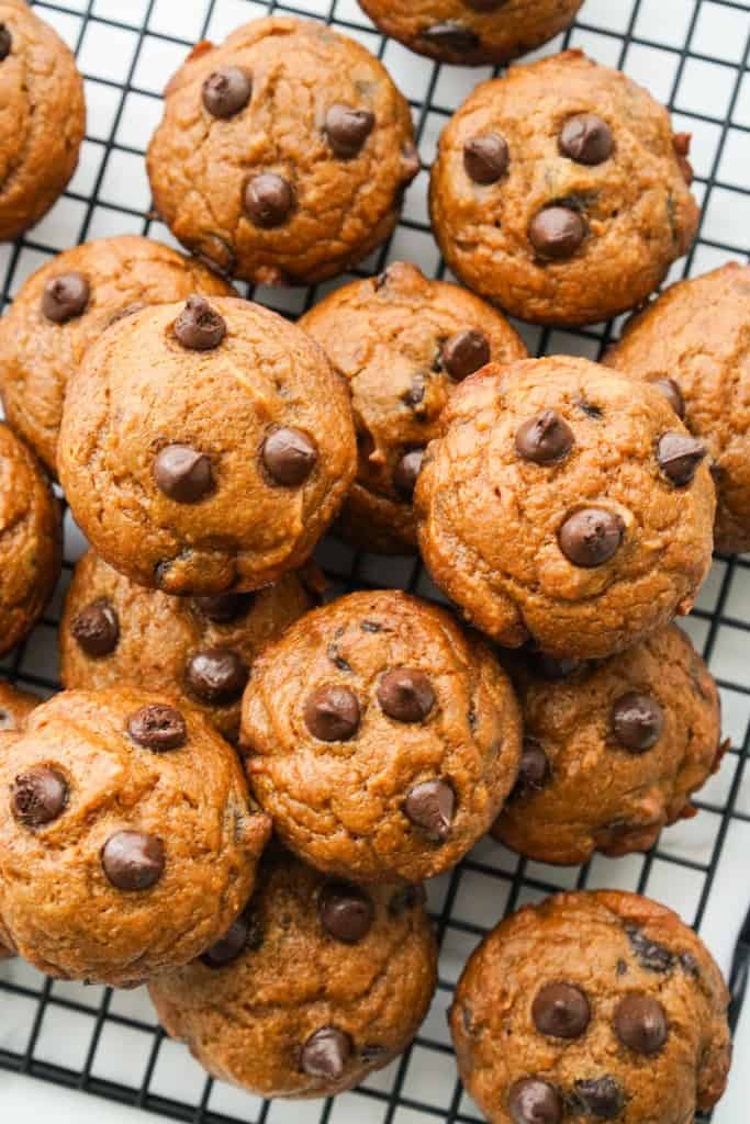 Pumpkin chocolate chip muffins stacked on a cooling rack